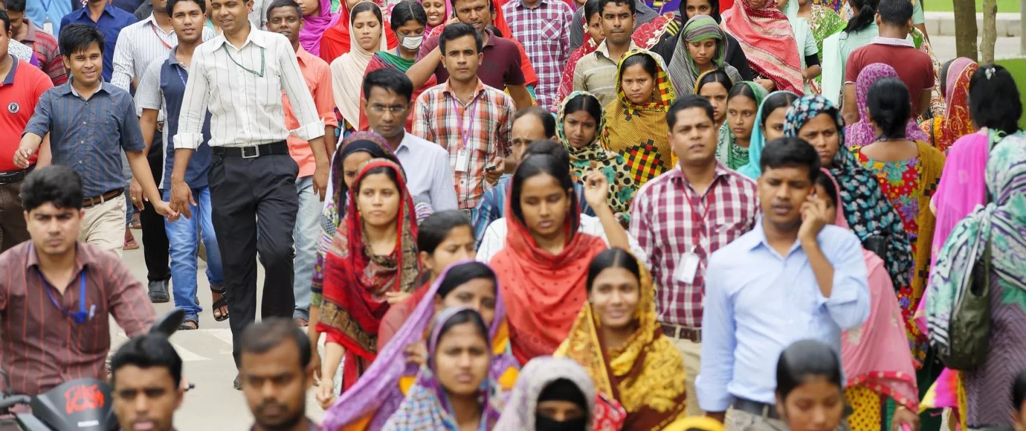 This is a photograph of workers from a readymade garment factory leaving work at the end of the day.