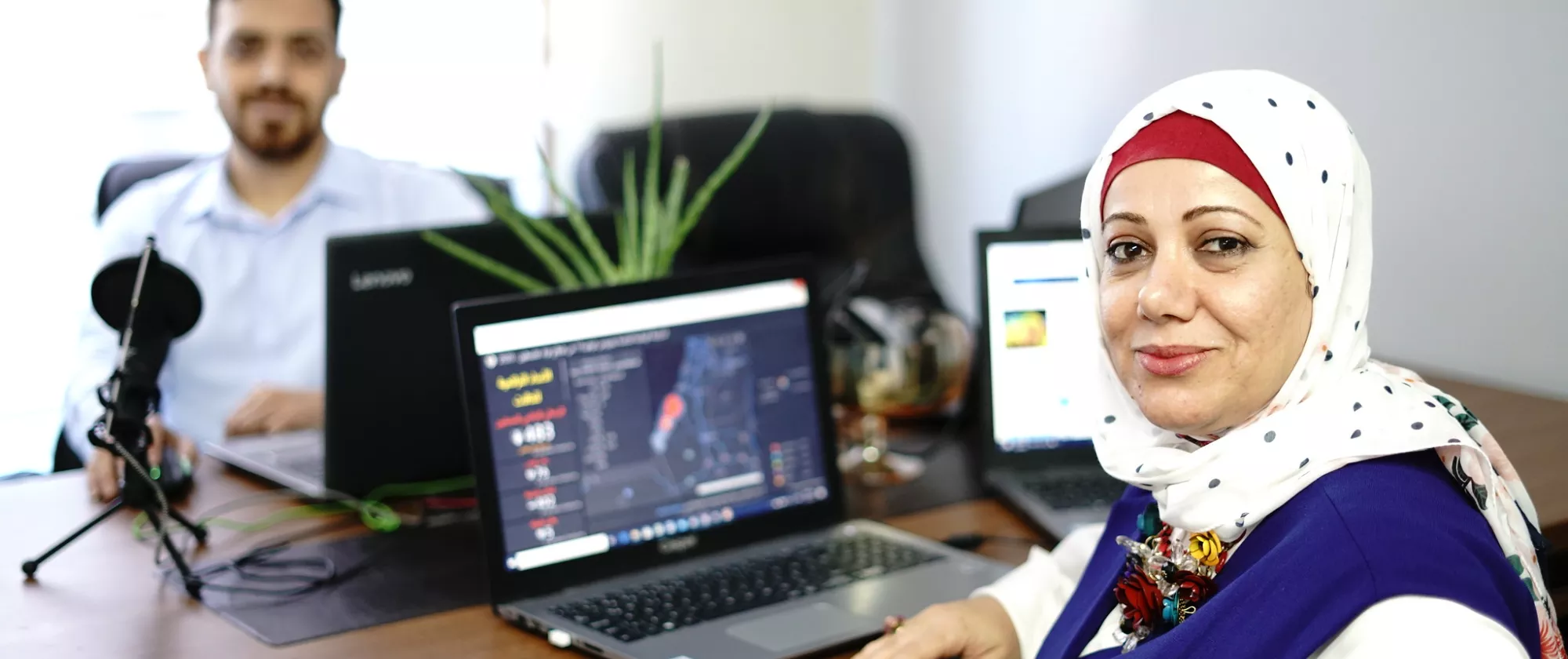 Woman sitting at computer across from male co-worker