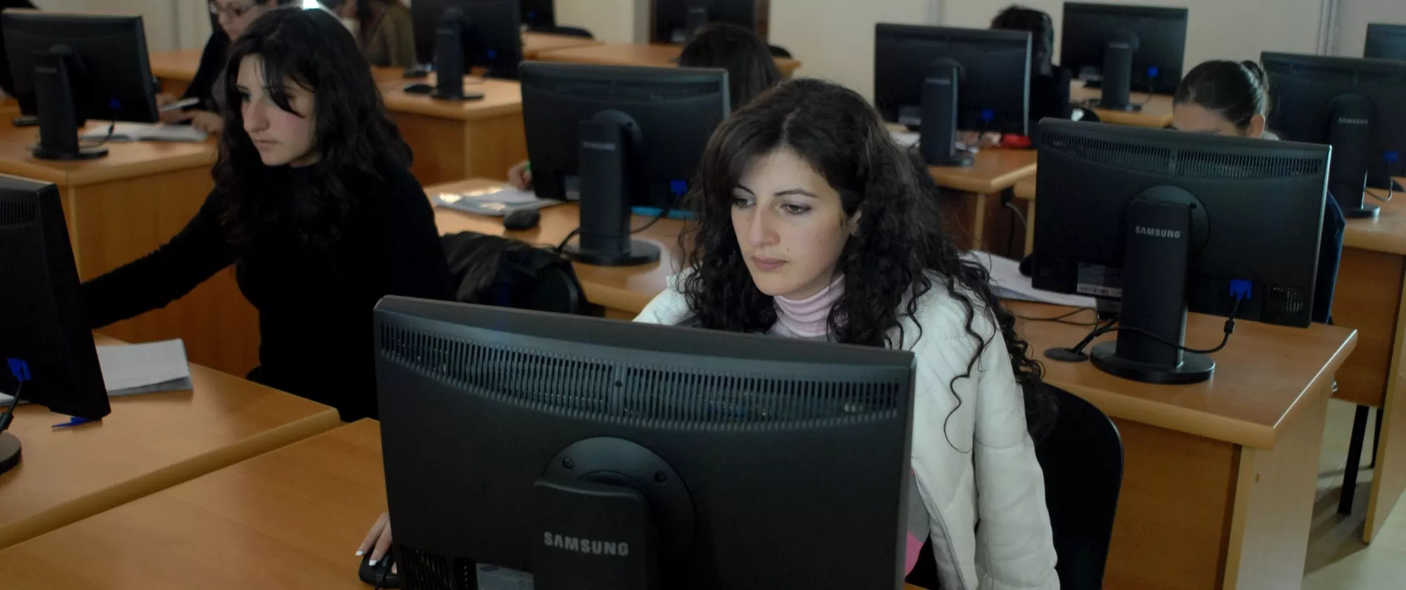 Group of young people in a classroom working on computers