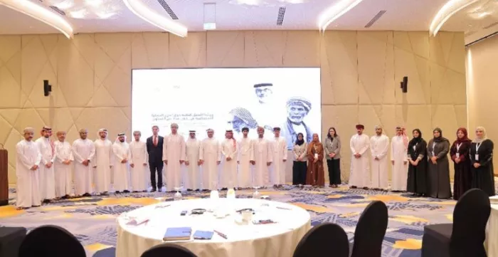 A group of men and women line up from the GCC countries during a meeting for a photo pose