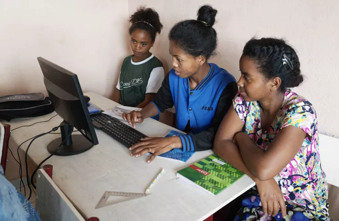 3 young women working together on one computer