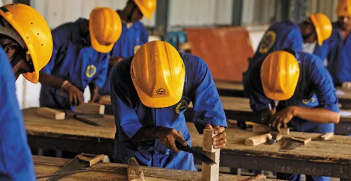 Skilled workers working in woodwork wearing safety suits